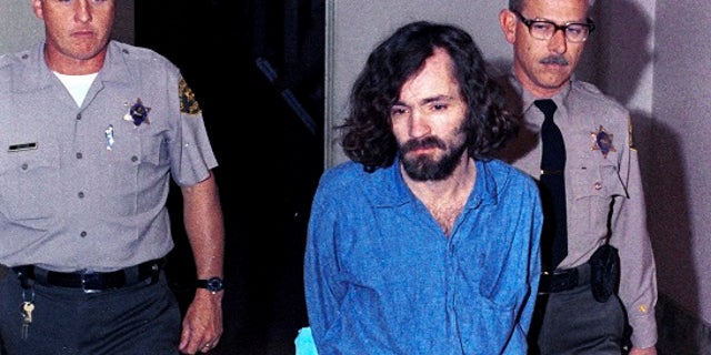 FILE â In this Aug. 20, 1970, file photo, Charles Manson, head of the cultic "Manson Family" charged with murder-conspiracy in the Tate-LaBianca slayings, is escorted by deputy sheriffs to court in Los Angeles. The AP reported Friday, June 23, 2017, that stories claiming Manson is dead or free on parole are false, with California corrections officials verifying Manson remains incarcerated. (AP Photo/File)