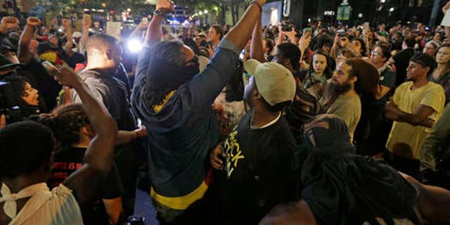 Protesters shout as they march downtown on the third night of protests in Charlotte, N.C. Thursday, Sept. 22, 2016, following Tuesday's fatal police shooting of Keith Lamont Scott in Charlotte, N.C. (AP Photo/Chuck Burton)