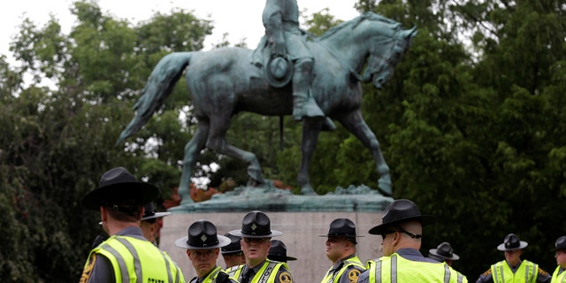 Virginia State Troopers stand beneath a statue of Robert E. Lee prior to a white supremacist rally.