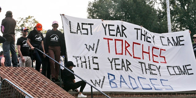 Demonstrators carry banners on the campus of the University of Virginia during a rally for the anniversary of last year's Unite the Right rally in Charlottesville, Va., Saturday.