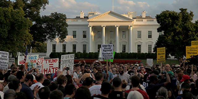 People gather for a vigil in response to the death of a counter-demonstrator at the "Unite the Right" rally in Charlottesville, outside the White House in Washington, U.S. August 13, 2017. REUTERS/Jonathan Ernst - RTS1BO8K