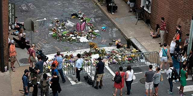 Mourners surround an impromptu memorial after the death of a young woman after a "Unite the Right" attendee rammed his car into counter-protesters.