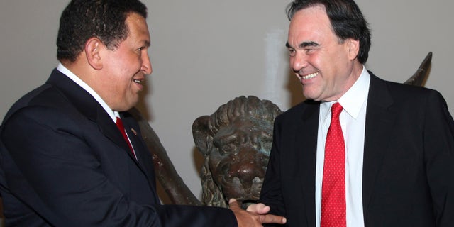 Venezuela's President Hugo Chavez (L) shakes hand with U.S. film director Oliver Stone during the "South Of The Border " premiere at the Sala Grande during the 66th Venice Film Festival September 7, 2009. REUTERS/Alessandro Bianchi (ITALY ENTERTAINMENT POLITICS) - RTR27JTQ