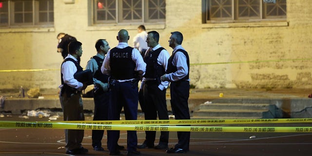 CHICAGO, IL - SEPTEMBER 19: Police investigate the scene in Cornell Square Park on the Southside where 11 people including a three-year-old child were shot on September 19, 2013 in Chicago, Illinois. Eighteen people were reported shot in the city, including one fatally, in less than a four-hour period on Thursday evening. (Photo by Scott Olson/Getty Images)