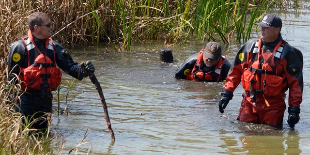 Sept. 6, 2015: Chicago Police Marine Unit divers search a lagoon at Garfield Park, in Chicago, where a toddler's decomposed head, feet and hand were found.