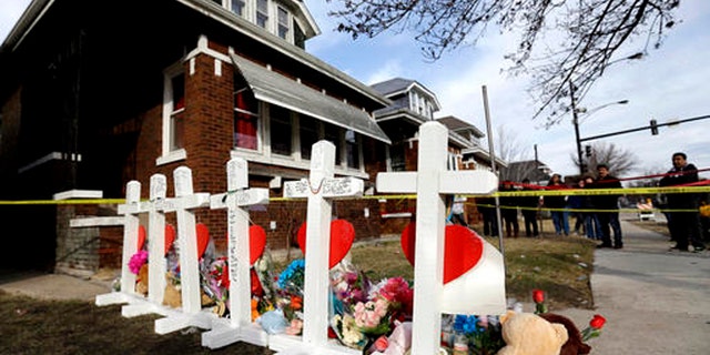 In this Feb. 7, 2016 file photo, mourners pay their respect outside a home in Chicago where six family members were found dead.