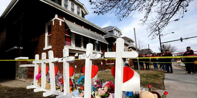 In this Feb. 7, 2016 file photo, mourners pay their respect outside a home in Chicago where six family members were found dead.