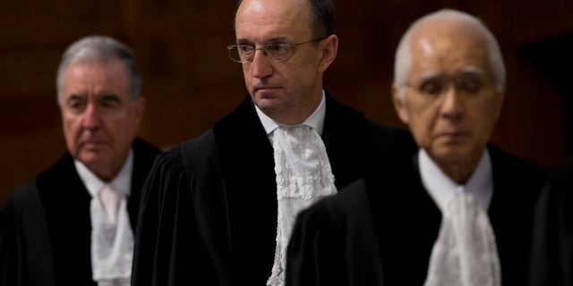 Presidente Peter Tomka de Eslovaquia, centro, juez Hisashi Owada de Japón, derecha y vicepresidente Bernado Setulveda-Amor de México toman asiento para leer el fallo de la Corte Internacional de Justicia de la Haya sobre el diferendo marítimo entre Chile y Perú, lunes 27 de enero de 2014. La corte superior de las Naciones Unidas trazó el lunes una nueva frontera marítima entre Perú y Chile que otorga a Perú parte de la zona disputada del Océano Pacífico pero deja en manos chilenas la rica zona pesquera. (AP Foto/Peter Dejong)