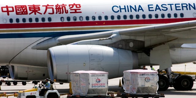 Aug. 29, 2007: A carter drives past a China Eastern airliner parked at the Beijing International Airport in Beijing, China.