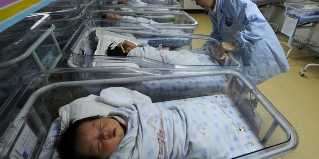 A nurse takes care of newborn babies at a hospital in Hefei, Anhui province April 2011.