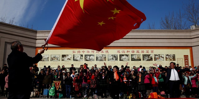 File photo: A man waves the Chinese national flag as an amateur choir performs in a park in a residential neighborhood in Beijing, China February 28, 2017. (REUTERS/Thomas Peter)