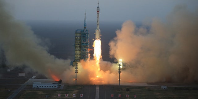 In this photo provided by China's Xinhua News Agency, the Long March-2F carrier rocket carrying China's Shenzhou 11 spacecraft blasts off from the launch pad at the Jiuquan Satellite Launch Center in Jiuquan, northwest China's Gansu Province, Monday, Oct. 17, 2016.