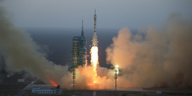 In this photo provided by China's Xinhua News Agency, the Long March-2F carrier rocket carrying China's Shenzhou 11 spacecraft blasts off from the launch pad at the Jiuquan Satellite Launch Center in Jiuquan, northwest China's Gansu Province, Monday, Oct. 17, 2016.