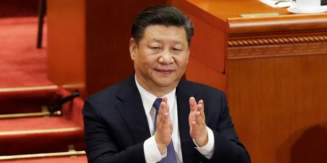 Chinese President Xi Jinping applauds after the parliament passed a constitutional amendment lifting presidential term limits, at the third plenary session of the National People's Congress (NPC) at the Great Hall of the People in Beijing, China March 11, 2018.  (REUTERS/Jason Lee)