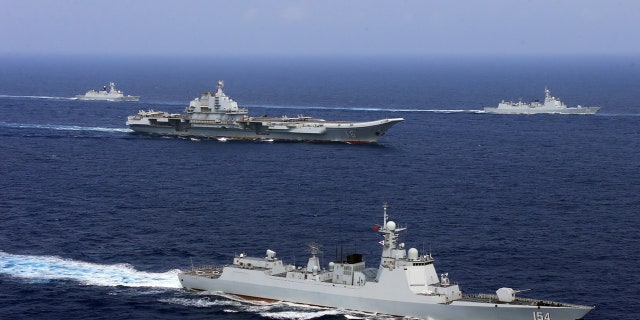 China's aircraft carrier Liaoning (C) takes part in a military drill of Chinese People's Liberation Army (PLA) Navy in the western Pacific Ocean, April 18, 2018.