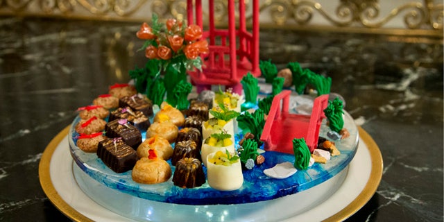 Sept. 24, 2015: The dessert called "a stroll through the garden" composed of handmade chocolate pavilion and bridge, pulled sugar roses, and white lotus flowers, that symbolize good fortune, is shown during a preview in the State Dining Room of White House in Washington for the state dinner of the visiting Chinese President Xi Jinping.(AP)