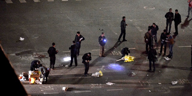 Mar 1. 2014: Police officers investigate the crime scene outside a railway station after an attack by knife wielding men leaving some 27 people dead in Kunming, in southwestern China's Yunnan province.