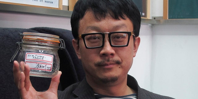 April 5, 2014: In this photo, Beijing artist Liang Kegang poses with the jar of fresh air collected in Provence, France, in an art gallery in Beijing, China.