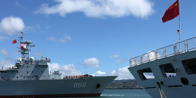 June 24, 2014: The Chinese People's Liberation Army (PLA) Navy replenishment ship Qiandaohu (866) (L) sails past the PLA Navy hospital ship, Peace Ark, as it docks at the Joint Base Pearl Harbor Hickam to participate in the multi-national military exercise RIMPAC 2014, in Honolulu, Hawaii.