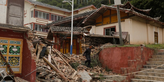 A man walks through the debris of a building that was damaged during an earthquake next to a temple compound in Jiuzhaigou, Sichuan province, China, August 10, 2017.