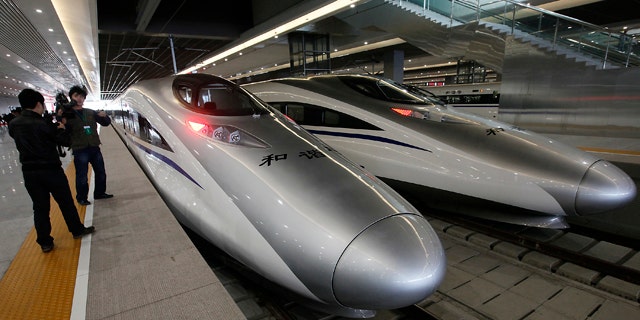 Journalists photograph the bullet trains of a new high-speed railway linking Shanghai with Hangzhou Tuesday, in Shanghai, China.