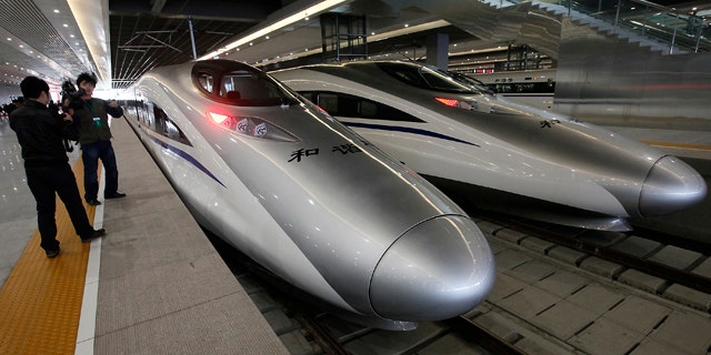 Journalists photograph the bullet trains of a new high-speed railway linking Shanghai with Hangzhou Tuesday, in Shanghai, China.
