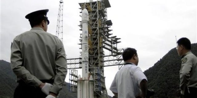 A security officer stands guard near the Long March 3D rocket with the Chang'e II lunar probe satellite loaded on its head. China's space ambitions continue to forge ahead as it now looks to build a full on space station to complement its lunar probes.