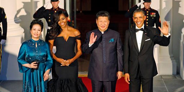 Sept. 25, 2015: President Barack Obama, right, and Chinese President Xi Jinping, second from right, wave along with, wives Peng Liyuan, left, and first lady Michelle Obama as they arrive for a state dinner at the White House in Washington.