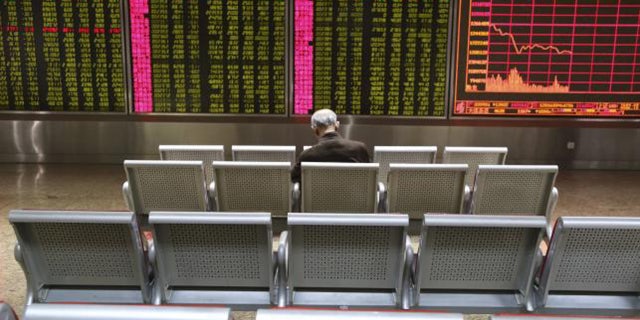 Jan. 4, 2016: An investor sits in front of a display board showing stock information at a brokerage house in Beijing. (Reuters/Li Sanxian)