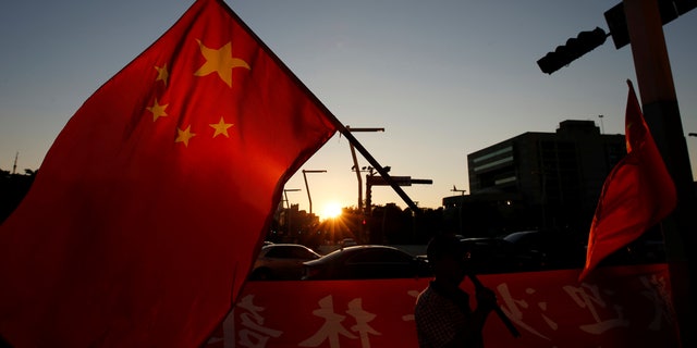 A pro-China supporter holds Chinese national flag, outside the dinner venue of Sha Hailin, a member of Shanghais Communist Party standing committee, in Taipei, Taiwan August 22, 2016. (REUTERS/Tyrone Siu)