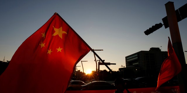 A pro-China supporter holds Chinese national flag, outside the dinner venue of Sha Hailin, a member of Shanghais Communist Party standing committee, in Taipei, Taiwan August 22, 2016. (REUTERS/Tyrone Siu)