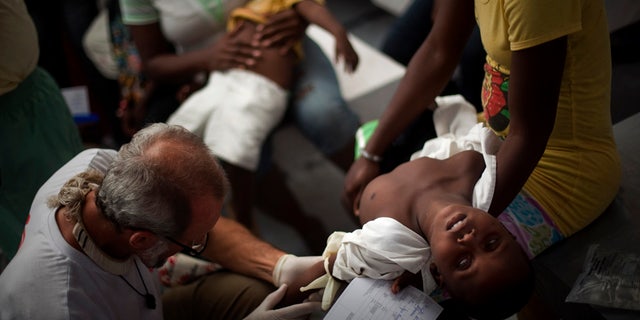 A child suffering cholera symptoms is checked by a doctor at the Doctors Without Borders temporary hospital in Port-au-Prince, Haiti, Tuesday Nov. 16, 2010. Thousands of people have been hospitalized for cholera across Haiti with symptoms including serious diarrhea, vomiting and fever and hundreds have died. (AP Photo/Emilio Morenatti)
