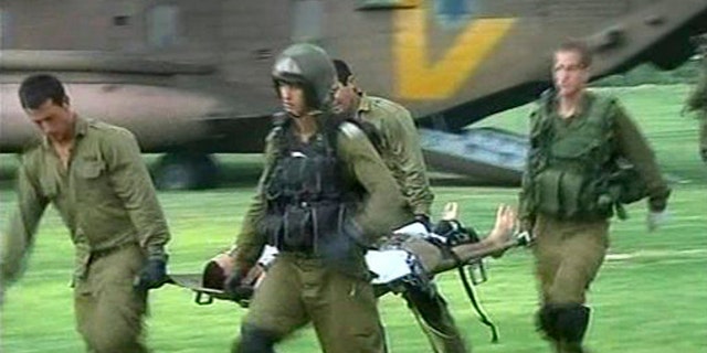 In this image provided by Associated Press Television News, an injured man is carried on a stretcher by helicopter crew on arrival at Soroka hospital in Beersheba, Israel, Aug. 18.