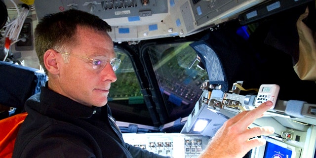 Astronaut Chris Ferguson, STS-135 commander, is pictured at the commander's station on the forward flight deck of the space shuttle Atlantis during the STS-135 mission's third day in space.