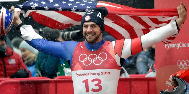 American Chris Mazdzer celebrates his historic silver medal win by eating a slice of pizza in one bite.