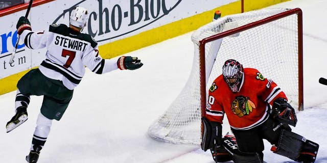 Minnesota Wild right wing Chris Stewart (7) celebrates his goal as Chicago Blackhawks goalie Corey Crawford (50) looks on during the second period of an NHL hockey game on Sunday, Jan. 15, 2017, in Chicago. (AP Photo/Matt Marton)