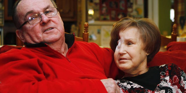 Bob Niles, left, puts his arm around his wife Karen Niles, right, in their home in Blackwell, Okla., in this photo taken Monday, Feb. 14, 2011. (AP)