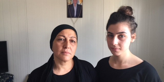 Fryal Abbo, with her teen daughter, Najma, mourns the death of her husband. He was killed for selling alcohol in a Christian shop two days before Christmas last year.