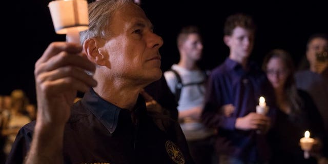 Texas Gov. Greg Abbott participates in a candlelight vigil for the victims of a fatal shooting at the First Baptist Church in Sutherland Springs, Sunday, Nov. 5, 2017, in Sutherland Springs, Texas. A man opened fire inside of the church in the small South Texas community on Sunday, killing more than 20 people.