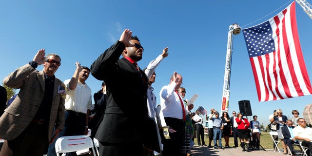 Ricky Checo, center, of the Dominican Republic, takes the oath of allegiance along with other immigrants during a citizenship ceremony at Liberty State Park, Thursday, Sept. 17, 2015, in Jersey City, N.J. Constitution Day and Citizenship Day is celebrated each year on Sept. 17, on the anniversary of the signing of the Constitution in 1787. The U.S. Citizenship and Immigration Services is expected to welcome more than 36,000 new citizens during more than 200 naturalization ceremonies across the country from Sept. 17-23. (AP Photo/Julio Cortez)