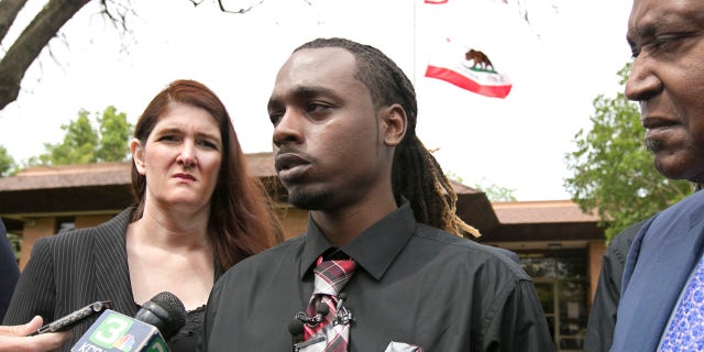 Nandi Cain, center, answers a reporters question concerning the alleged beating he received from a Sacramento Police officer two weeks ago during a news conference Monday, April 24, 2017, in Sacramento, Calif.