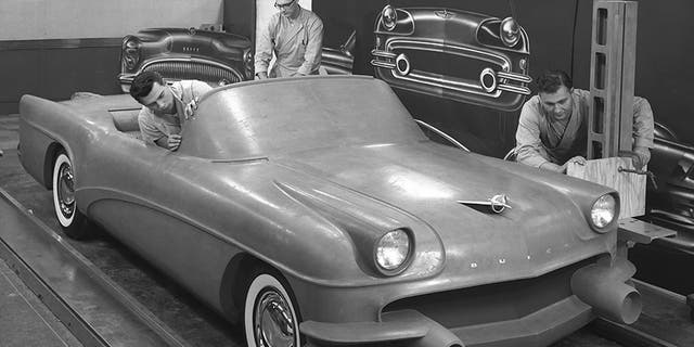 This 1954 photo Courtesy of General Motors shows Buick Design Studio creative clay sculptors as they mold the clay on a model GM automobile. (Courtesy of General Motors via AP)