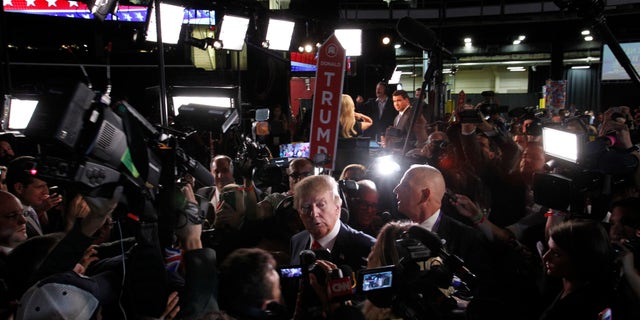 Republican 2016 U.S. presidential candidate businessman Donald Trump is surrounded by news media in the "spin room" after the conclusion of the first official Republican presidential candidates debate of the 2016 U.S. presidential campaign in Cleveland, Ohio, August 6, 2015.
