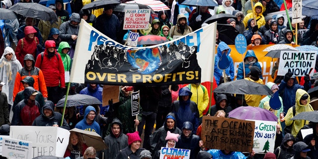 Demonstrators march on the State Street during "100 Days of Failure" protest and march, Saturday, April 29, 2016, in Chicago. Thousands of people across the U.S. are marking President Donald Trump's hundredth day in office by marching in protest of his environmental policies. (AP Photo/Nam Y. Huh)