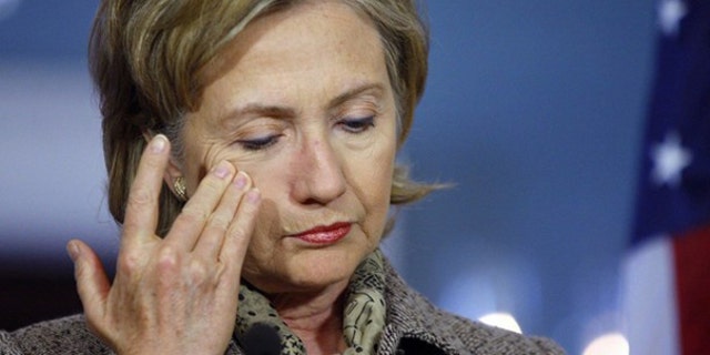 Hillary Clinton wipes her face during a press conference in Washington.