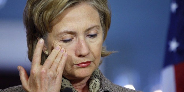 Hillary Clinton wipes her face during a press conference in Washington.