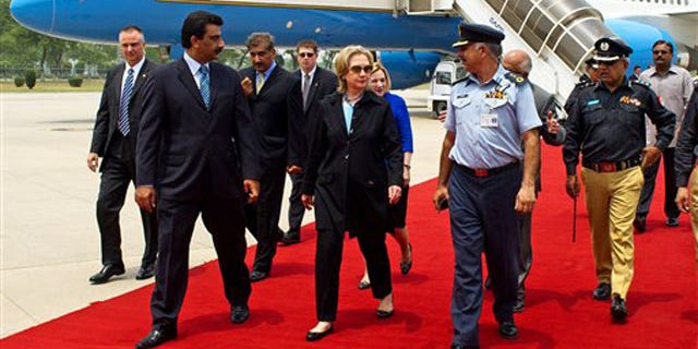Secretary of State Hillary Clinton, center, walks on the red carpet upon her arrival at PAF Base Chakala in Islamabad July 18. (AP Photo)