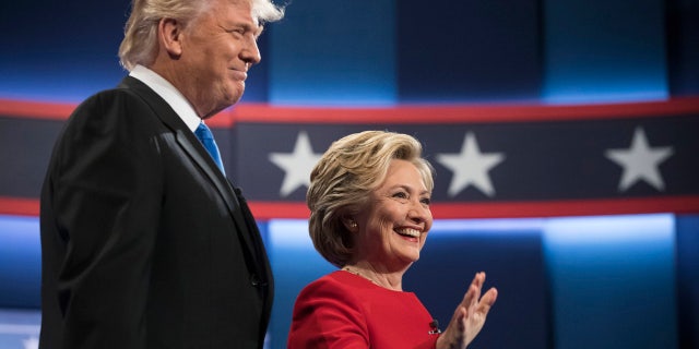 Democratic presidential nominee Hillary Clinton, right, stands with Republican presidential nominee Donald Trump at the start of the presidential debate at Hofstra University in Hempstead, N.Y., (AP Photo/Matt Rourke)