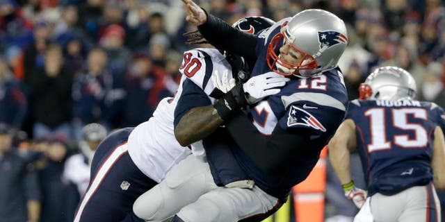 Houston Texans defensive end Jadeveon Clowney (90) levels New England Patriots quarterback Tom Brady (12) after he threw a pass during the first half of an NFL divisional playoff football game, 星期六, 一月. 14, 2017, in Foxborough, 弥撒.