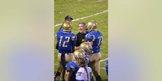 Former Bremerton High School assistant football coach Joe Kennedy stands at the center of the field on the 50 yard line at Bremerton Memorial Stadium.